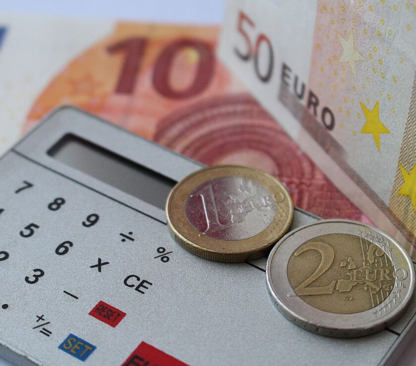 Calculadora y facturas sobre escritorio, cálculo de pagos del Estado