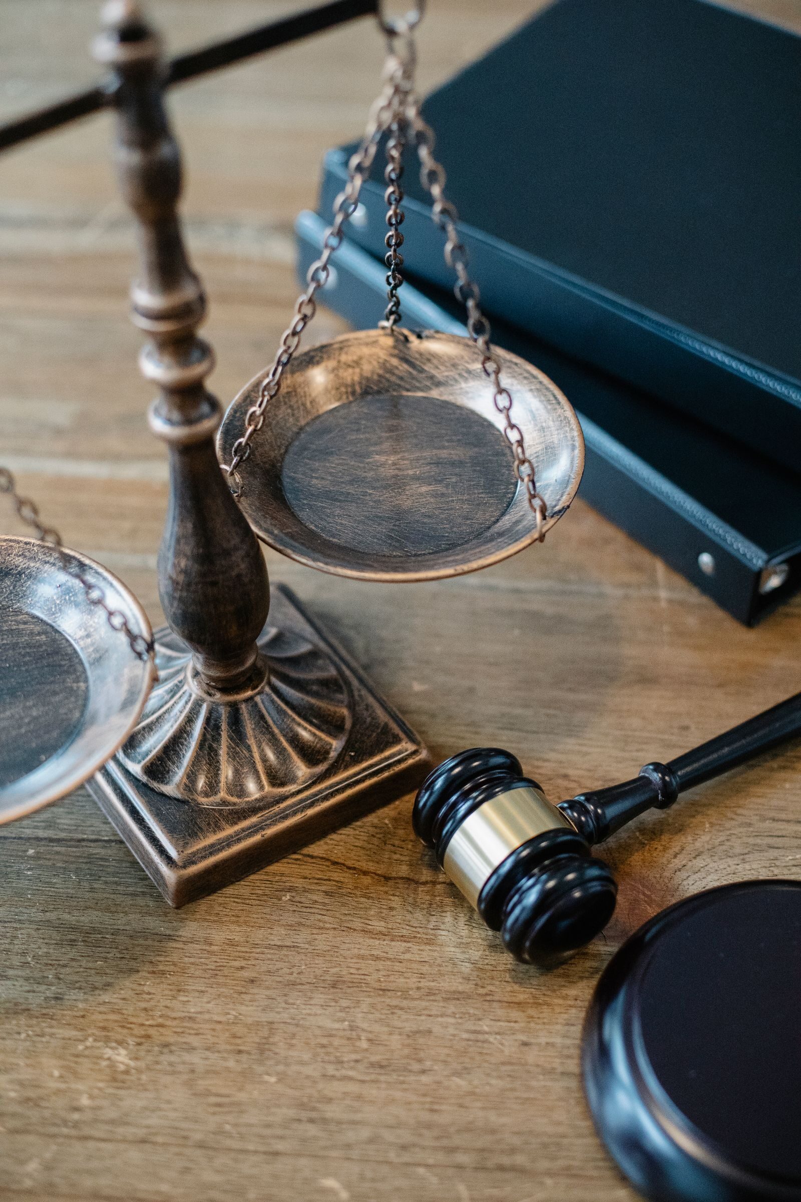 Balanza de la justicia, mazo y libros de derecho sobre mesa de madera
